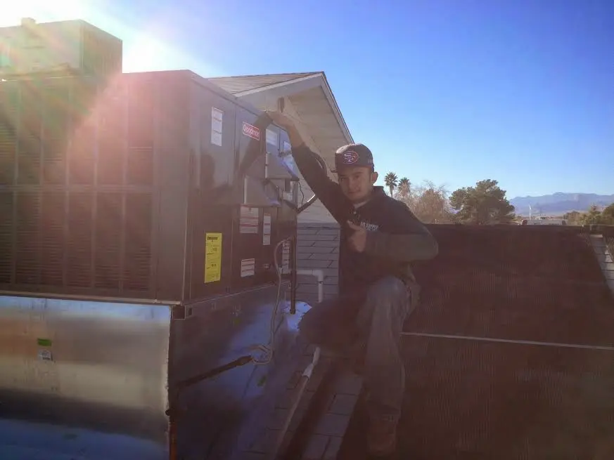 HVAC technician performing AC Tune-Up on a rooftop unit in Lemont
